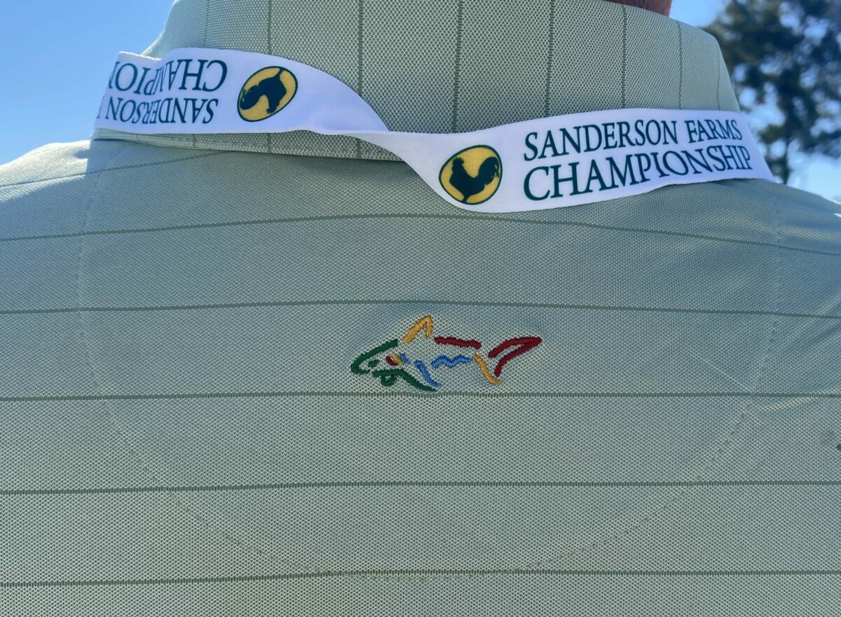 Why is Greg Norman’s logo on volunteers’ clothing at the Sanderson Farms Championship?